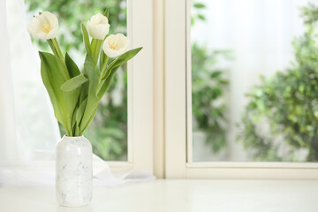 Beautiful fresh flowers on window sill indoors. Space for text