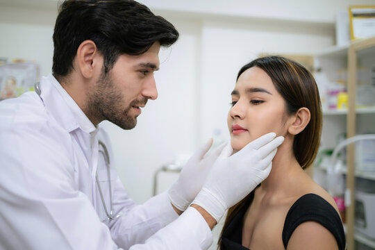 Doctor in uniform wearing glove and touch woman face. Check skin before plastic surgery in the clinic. Cosmetology and skin care concept. Lightening and smoothing wrinkles on the face skin