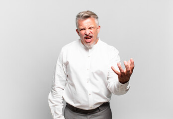 senior businessman looking angry, annoyed and frustrated screaming wtf or what’s wrong with you
