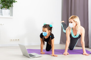 Obraz premium Young fitness sport woman training and wearing disposable medical mask. TRX concept isolated on white background.