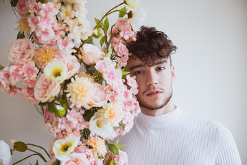 Junger Mann posiert mit Blumenranke