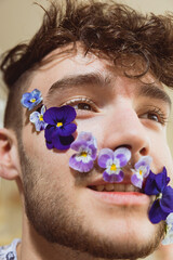 Junger Mann mit Blumenranke im Gesicht