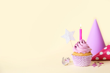 Delicious birthday cupcake with burning candle and party decor on beige background, space for text