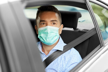 Fototapeta na wymiar man or male passenger wearing mask in car
