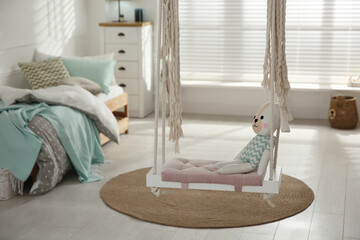 Stylish swing with toy in child's room. Interior design