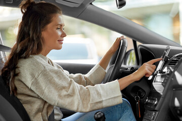 smiling woman or female driver driving car in city