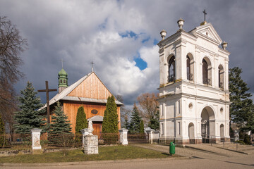 Fototapeta premium Wooden church and historic brick belfry in Warszawice, Masovia, Poland
