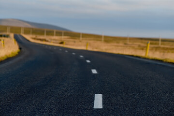 a deserted asphalt road running away into the hills. Iceland. The spirit of travel and adventure.
