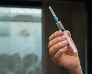 Doctor hand holding injector syringe with vaccine or medicine