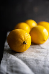 Ripe bright lemons on the dark rustic background. Selective focus. Shallow depth of field.