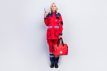 Full length photo of charming happy positive woman hold radio ambulance medic bag serious isolated on grey color background © deagreez