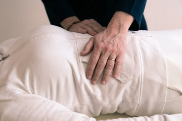 Therapist man doing Holistic therapy Reiki to a woman. Energy treatment with the heat of the palm hands. Japanese energy healing. Wellness, health, relax, well-being and alternative medicine concept.