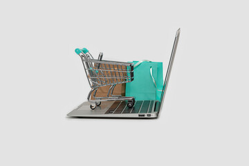 online shopping concept with laptop computer, shopping bag and cart isolated on white, copy space