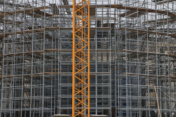 Construction crane in front of the building with scaffolding