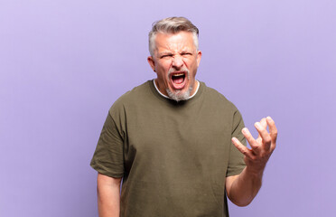 old senior man looking angry, annoyed and frustrated screaming wtf or what’s wrong with you