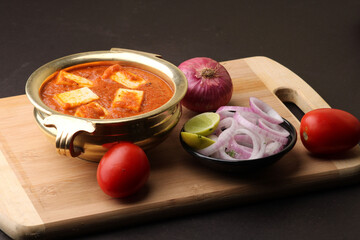 Fototapeta na wymiar Paneer Butter Masala also known as Panir makhani or makhanwala. served in brass bowl 