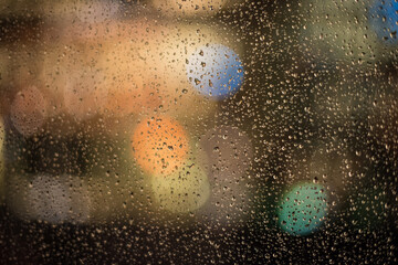 Fototapeta na wymiar raindrops and night lights through the window 