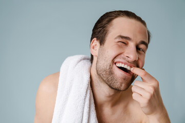 Happy brunette bearded shirtless man with towel