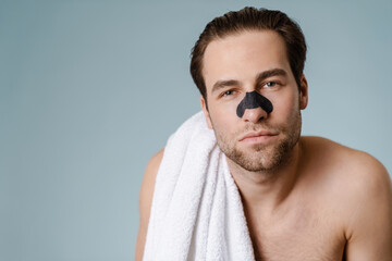 Close up of a brunette shirtless man with stubble