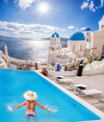 Santorini island with young woman in the swimming pool in Oia village against traditional churches,...
