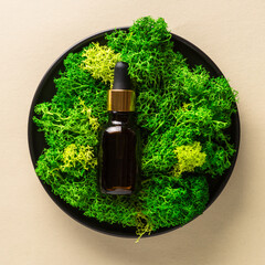 Serum bottle with moss at natural background.