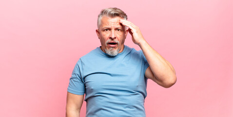 old senior man looking happy, astonished and surprised, smiling and realizing amazing and...
