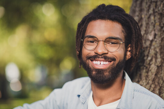 Close-up portrait of attractive cheerful guy spending time in green forest wood sunny day outside outdoor