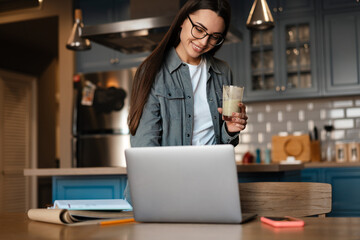 Happy mid aged brunette woman holding glass with beverage