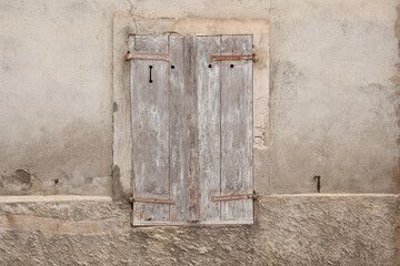 Closed wooden shutters on a old house in a toned image
