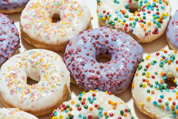 Too much sugar. Close up shot of assorted round glazed donuts with colorful sprinkles