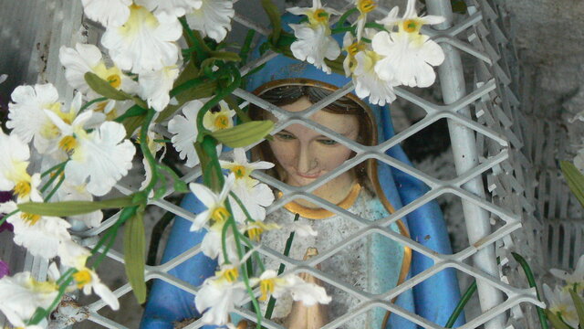 Zoom sur un autel champ&ecirc;tre de d&eacute;votion &agrave; la vierge prot&eacute;g&eacute; par une grille en losange