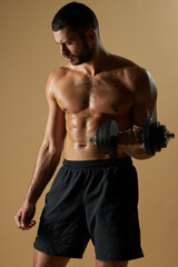 Fototapeta na wymiar Bearded athlete man developing strength with special tool while posing in studio