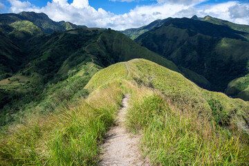 Green mountain ridge with walking path. Spectacular mountain landscape. Rural land scenery. Summer travel hiking in green hills. Untouched nature parkland. Volcanic island relief