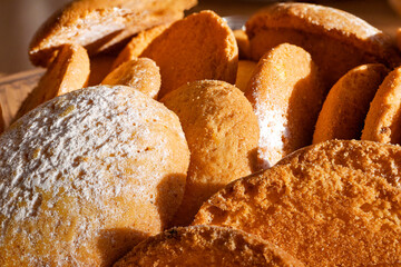 Crispy cookies sprinkled with powdered sugar under hard ligth.