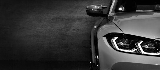 Front headlights of modern sport car black and white on black background, free space on left side...