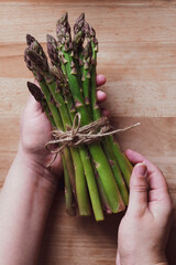 hands grabbing a bunch of fresh asparagus