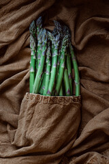 Bunch of fresh asparagus on an earth colored dish towel