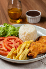 Executive dish with breaded fillet, rice, beans and salad.
