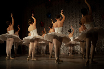 Ballerinas in white tutus show dance movement. The girls are doing ballet. Ballet dance class on...