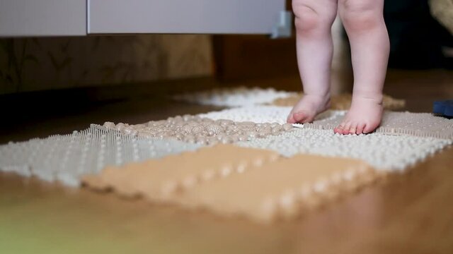 The little kid's legs walk on the massage mat.
