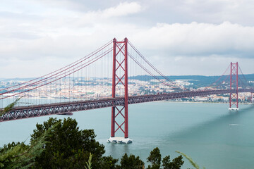 Fototapeta na wymiar Modern bridge On April 25 in Lisbon, the capital of Portugal, in cloudy cloudy weather, cars drive on the gigantic bridge across the strait.