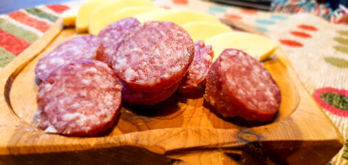 pre-lunch  cheese  and  salami  cut  on  a  wooden  board