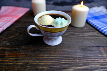 marshmallows in a cup of coffee on a wooden table. The concept of a cozy home with a cup of delicious coffee.