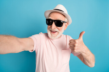 Naklejka premium Photo of aged man pensioner happy positive smile make selfie show thumb-up like cool isolated over blue color background