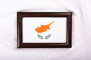 Cyprus flag in a realistic frame on white cloth background flat lay photo