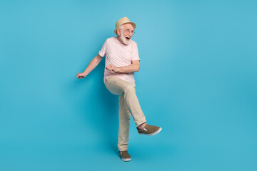 Full length photo of aged man pensioner happy positive smile excited have fun dance isolated over blue color background