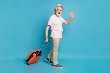 Full body profile side photo of aged man happy positive smile go walk check-in plane luggage travel isolated over blue color background