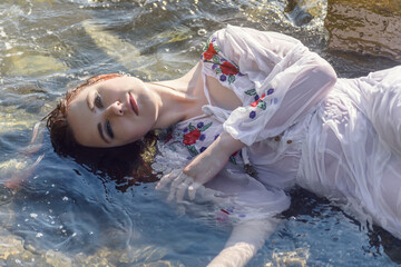 Young woman in white dress enjoys sea.