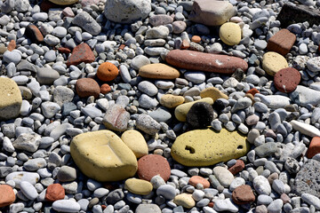 rock pebbles and cobble-sized brick stones on an urban lakefront beach 