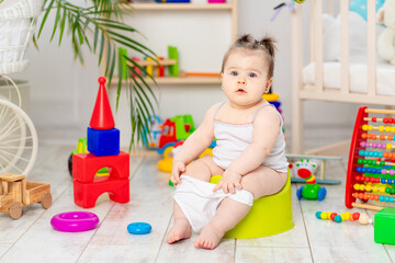 baby learns to walk on the potty in the nursery at home